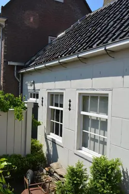 a white house with two windows on the side of it at Waterland Vakantiehuis in Monnickendam