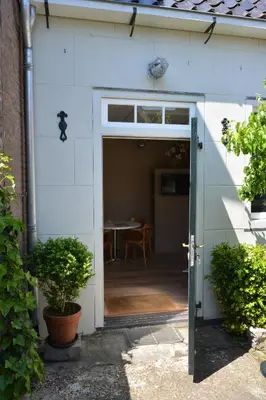 an open door of a house with a table at Waterland Vakantiehuis in Monnickendam