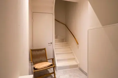 a room with a staircase with a chair and a stair case at Townhouse 't Raap in Amsterdam