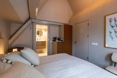 a bedroom with a white bed and a staircase at Townhouse 't Raap in Amsterdam
