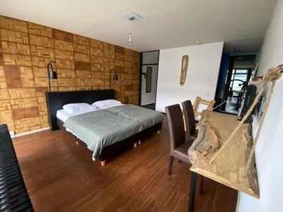 a bedroom with a bed and a chair in it at Anno in Almere