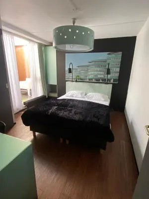 a bedroom with a black bed with a black blanket at Anno in Almere