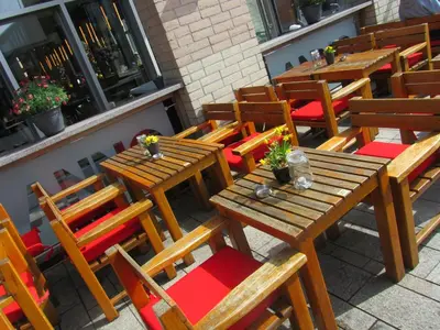 a group of wooden tables and chairs in a restaurant at Anno in Almere