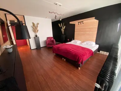 a bedroom with a large bed with a red blanket at Anno in Almere