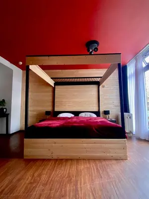 a large bed in a room with a red wall at Anno in Almere