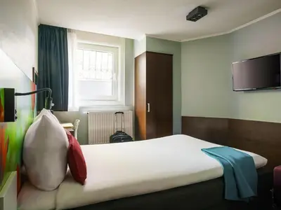 a hotel room with a bed and a flat screen tv at ibis Styles Amsterdam City in Amsterdam
