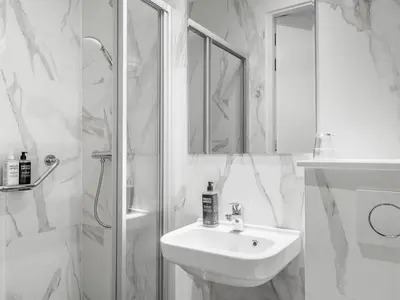 a white bathroom with a sink and a shower at ibis Styles Amsterdam City in Amsterdam