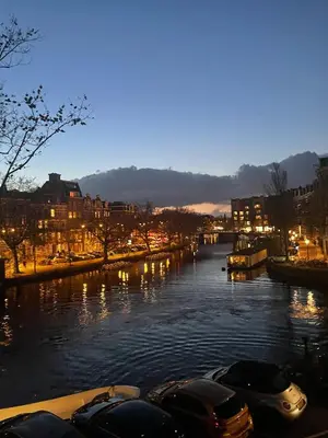 a river with boats on it at night at Canal view home in the center in Amsterdam