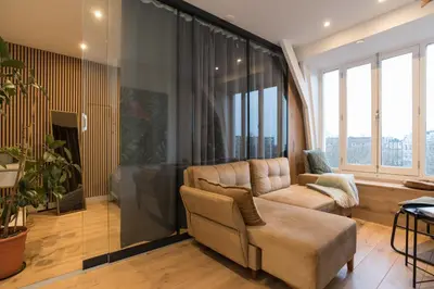 a living room with a couch and a large window at Canal view home in the center in Amsterdam