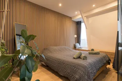 a bedroom with a bed with a striped wall at Canal view home in the center in Amsterdam