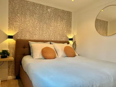 a bedroom with a bed with two pillows and a mirror at Lovely tiny house in Zandvoort