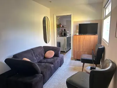 a living room with a couch and a tv at Lovely tiny house in Zandvoort
