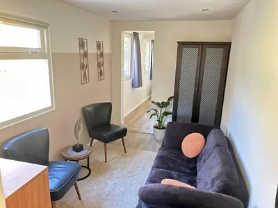 a living room with a couch and two chairs at Lovely tiny house in Zandvoort