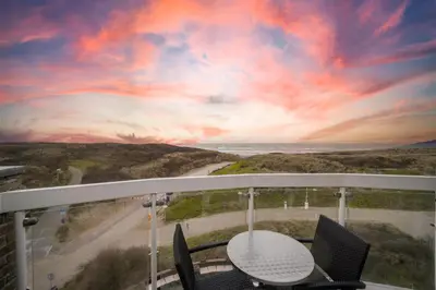 a view from a balcony with a table and chairs at Fletcher Hotel Restaurant Zeeduin in Wijk aan Zee