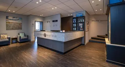 a lobby of a pharmacy with a counter and chairs at Fletcher Hotel Restaurant Zeeduin in Wijk aan Zee
