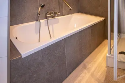 a bathtub with a faucet in a bathroom at Hotel Hoogland Zandvoort aan Zee in Zandvoort