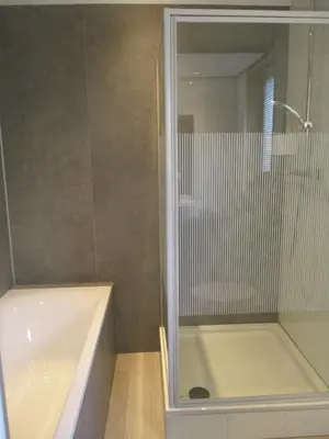 a bathroom with a white bath tub and a mirror at Hotel Hoogland Zandvoort aan Zee in Zandvoort
