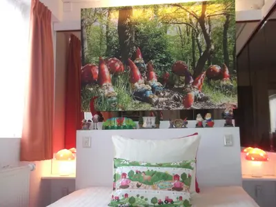 a bedroom with a painting on the wall above a bed at Hotel Hoogland Zandvoort aan Zee in Zandvoort