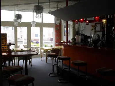 a restaurant with a bar with a table and chairs at Hotel Hoogland Zandvoort aan Zee in Zandvoort