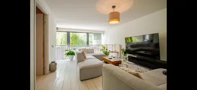 a living room with a couch and a flat screen tv at Quiet Garden Room Amsterdam West - by Peter in Amsterdam