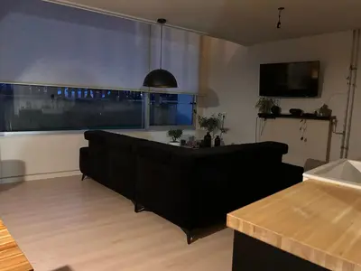 a living room with a couch and a large window at Quiet Garden Room Amsterdam West - by Peter in Amsterdam