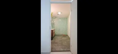 a hallway of a bathroom with a sink and a mirror at Quiet Garden Room Amsterdam West - by Peter in Amsterdam