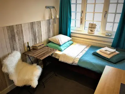 a room with a bed with a table and a window at Bed & Breakfast Hotel Zandvoort in Zandvoort