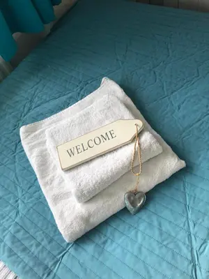 a towel with a welcome tag on a bed at Bed & Breakfast Hotel Zandvoort in Zandvoort
