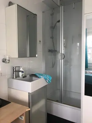 a white bathroom with a sink and a shower at Bed & Breakfast Hotel Zandvoort in Zandvoort