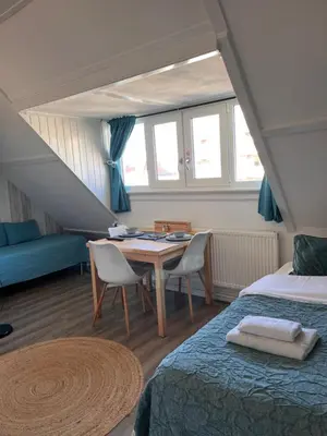 a bedroom with a bed and a table and chairs at Bed & Breakfast Hotel Zandvoort in Zandvoort