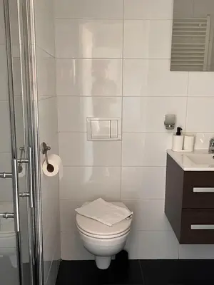 a white bathroom with a toilet and a sink at Bed & Breakfast Hotel Zandvoort in Zandvoort