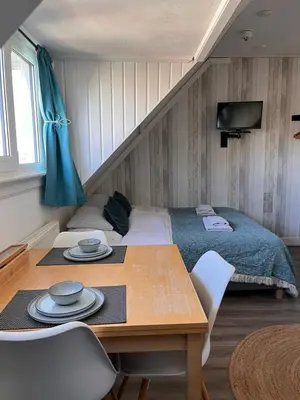 a bedroom with a bed and a table with chairs at Bed & Breakfast Hotel Zandvoort in Zandvoort