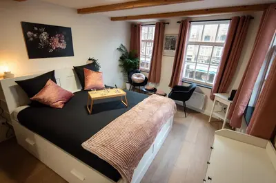 a bedroom with a large bed with a table on it at Best Neighbourhood Apartment in Amsterdam
