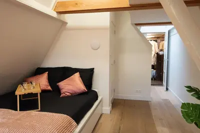a living room with a black couch with a table at Best Neighbourhood Apartment in Amsterdam