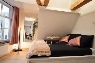 a bedroom with a bed and a table in it at Best Neighbourhood Apartment in Amsterdam