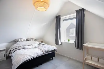 a bedroom with a bed and a window at De Strandwielen in Sint Maarten