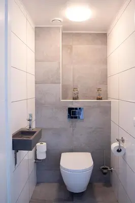 a bathroom with a white toilet and a sink at De Strandwielen in Sint Maarten