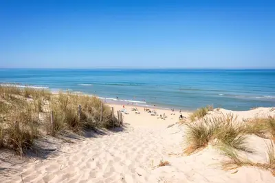 a beach with people on the sand and the ocean at Lakeside Cottage De Rijd in Nieuwe-Niedorp