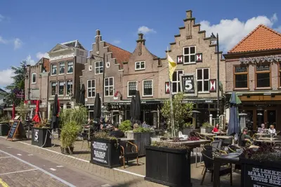 a street with tables and chairs in front of buildings at Lakeside Cottage De Rijd in Nieuwe-Niedorp