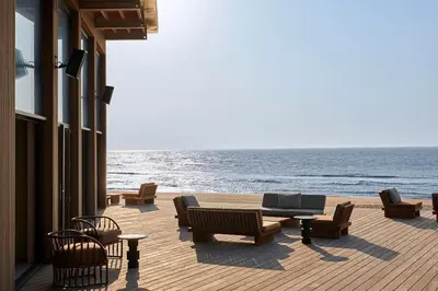 a patio with chairs and tables and the ocean at Cala Bassa Beach Boutique Apartments - Sea View in Overveen