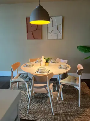 a dining room table with chairs and aendant light at Cala Bassa Beach Boutique Apartments - Sea View in Overveen