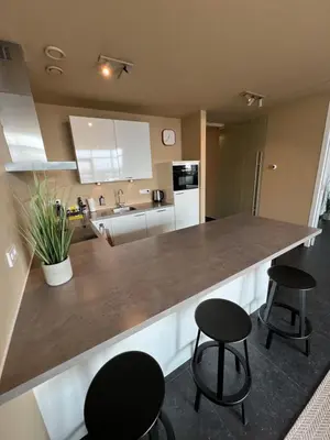 a kitchen with two black stools and a counter top at Cala Bassa Beach Boutique Apartments - Beach View in Overveen