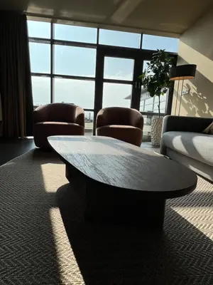 a living room with a coffee table and chairs at Cala Bassa Beach Boutique Apartments - Beach View in Overveen
