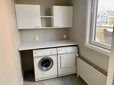 a laundry room with a washing machine and a window at welkom bij 5 in Den Ilp