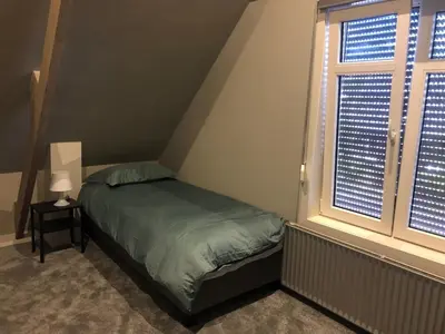 a small bedroom with a bed and a window at welkom bij 5 in Den Ilp