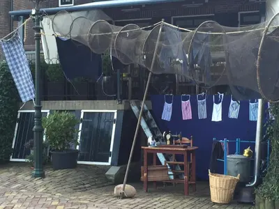 awning over a table in front of a blue building at Holiday in Spakenburg Groof in Spakenburg