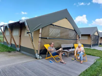 two people sitting in chairs in front of a tent at Camping De Boerinn in Kamerik