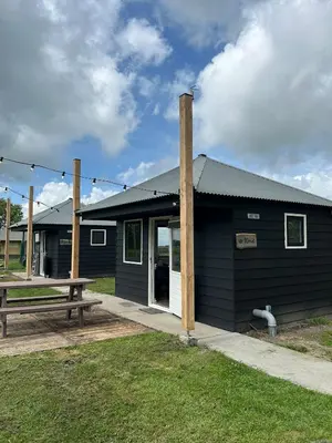 a black building with a picnic table in front of it at Camping De Boerinn in Kamerik