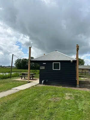 a blue building with a picnic table and a bench at Camping De Boerinn in Kamerik