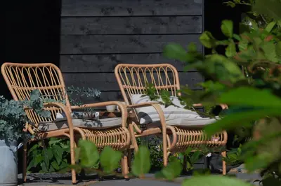 two wicker chairs with cushions sitting on a patio at Bedje in de polder in Montfoort